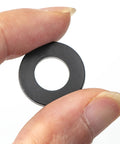 Close-up of a single black washer from Do It All Nylon Washer Kit 720 Pieces Assortment From M2 To M12 Flat Washers For Bolts And Screws PA66 Nylon Insulation Friendly 9 Sizes Durable Hardware Set For Mechanical And Electrical Jobs held between fingers.
