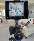 Tablet And Phone Tripod Mount Adapter With 1/4 Inch Thread And 17mm Ball Head holding tablet on tripod in living room