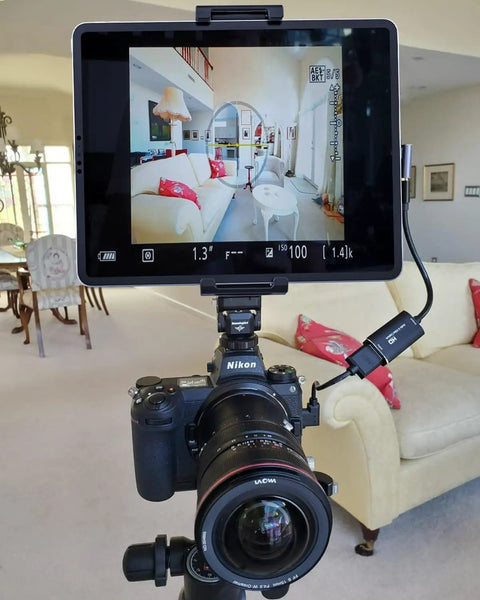 Tablet And Phone Tripod Mount Adapter With 1/4 Inch Thread And 17mm Ball Head holding tablet on tripod in living room