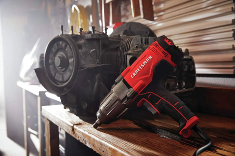 Half Inch Corded Impact Wrench, 7.5 Amp Power, 450 Ft Lbs Max Torque, placed on workbench beside engine component