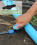 Hand adjusting 12 Pack One-Half Inch Drip Irrigation Barbed Valve Fittings With Ball Shut Off Barbed Switch Valves on blue tubing