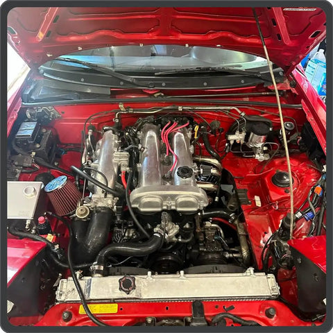180 Degree U Bend Silicone Hose Coupler 1 Inch ID 4 Ply Reinforced installed in a car engine bay with other components.