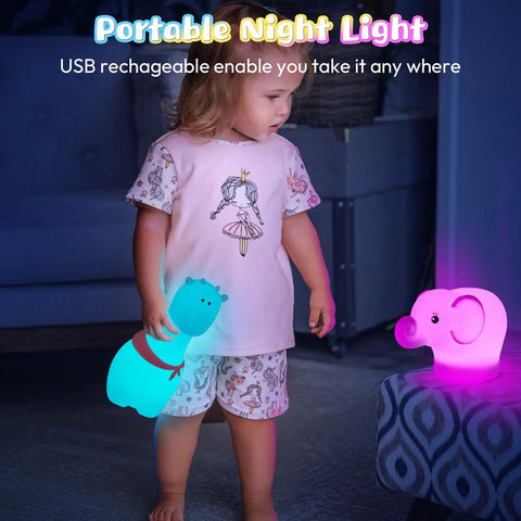 Child holding a glowing blue animal-shaped lamp, standing beside a pink elephant lamp on a stool in a dimly lit room.