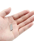 Hand holding three 100 Pcs Stainless Steel Shelf Dowel Pins 2mm By 22mm For Cabinet And Furniture Replacement Hardware.