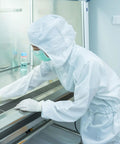 Grab This Legit Heavy Duty Anti Static Lab Coat Coverall Tailored For Electronics Manufacturing And Chemical Handling Featuring An Elastic Cuff Hooded Jumpsuit Unisex White Work Rig worn in a cleanroom setting.