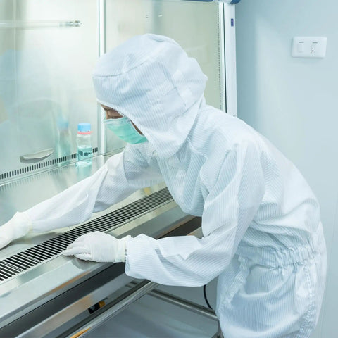 Grab This Legit Heavy Duty Anti Static Lab Coat Coverall Tailored For Electronics Manufacturing And Chemical Handling Featuring An Elastic Cuff Hooded Jumpsuit Unisex White Work Rig worn in a cleanroom setting.