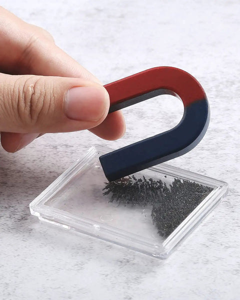 Hand holding U-shape magnet with iron filings in Magnetism Science Kit for Kids and Teens Hands On Physics Experiments STEM Education Toy Set