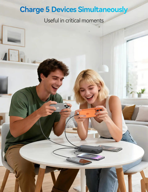 Two people using devices while charging with Ride Or Die Portable Charger With 32000Mah Capacity And Built In Cables Featuring Usb C Fast Charging For Phones Tablets All Day Juice Hardcore Build Quality.