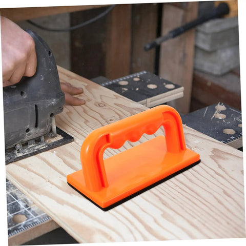 Orange Safety Push Block for Table Saws and Router Tables on a woodworking bench, guiding wood safely with precise control.
