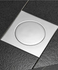 Ridiculously Durable Chrome Plated Brass Pop Up Floor Drain Plug For Bathtubs And Showers on black tiled floor.
