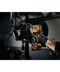 12V Max 3/8 Inch Cordless Impact Wrench Kit delivering Hella tight torque used for automotive repairs in a garage.