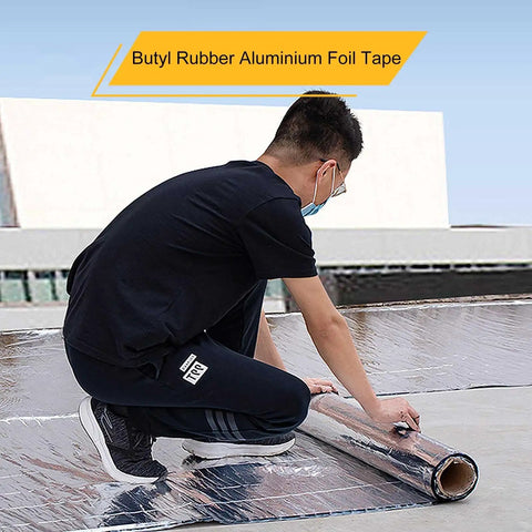 Person applying Heavy Duty Self Sealing Asphalt Tape With Aluminum Foil Backing Waterproof Bitumen Roll on roof surface.