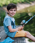 Child sitting by a lake using Portable Telescopic Kids Fishing Pole Set for Boys and Girls 2 Pack with Rod and Reel Includes Tackle Box