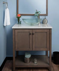 Slick Squared Vessel Faucet And Drain Set In Brushed Nickel Finish installed on wooden vanity with glass sink and mirror backdrop.