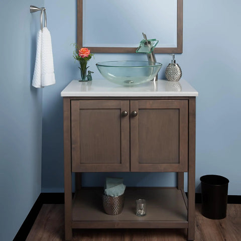 Slick Squared Vessel Faucet And Drain Set In Brushed Nickel Finish installed on wooden vanity with glass sink and mirror backdrop.