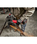 Heavy Duty 4 Inch Cordless Angle Grinder With Brushless Motor And M18 Battery Pack in action cutting metal, creating sparks.