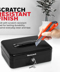 Compact Cash Box With Removable Money Tray And Under Tray Storage Five Coin Slots Durable Metal Safe With Key Lock Ideal For Home Office Black 0.14 Cu Ft Saving Money Lock Box shown in use with scratch test.