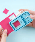 Lever Action Postage Stamp Punch 1x0.8 Inch Rectangular Stamp Shaped Paper Punch in use, cutting pink paper for crafting
