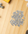 100 Pack Straight Up Sturdy Shelf Pegs For Wood Shelving Heavy Duty Metal Support Pins with smooth silver edges on wood surface.