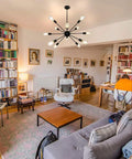 Sputnik Style Ceiling Light Fixture With 12 Lights Black Chandelier in modern living room with bookshelves and seating area