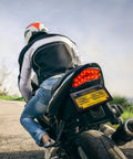 Rider on motorcycle with Two Pack Stainless Steel Motorcycle License Plate Frames In Black Finish Heavy Duty Metal Plate Cover.