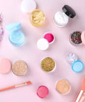 10 Piece Clear Acrylic Makeup Travel Jars With Lids In 0.11 Oz 0.18 Oz 0.35 Oz 0.53 Oz And 0.7 Oz Sizes Plus 5 Mini Spatulas on pink surface