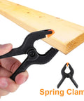 3 Inch Plastic Spring Clamps With Killer Anti Slip Grip Heavy Duty Woodworking And Backdrop Clips Hella Handy For Crafts Home Diy Total Flexible Tool Built Tough For Quick Projects holding on to a wooden plank.
