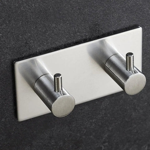 Heavy Duty Stainless Steel Wall Mounted Hooks Featuring Super Strong Self Adhesive Tape For Bathroom Towels Coats And Home Organization No Drill Hassle Rust Proof Daily Setup mounted on a dark wall.