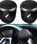 Pair of black steering wheel spinner knobs with silicone surface and metal bearings (2-pack) for 360° rotation, installed.
