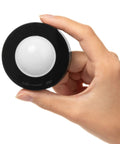 Hand holding black puck light from Under Cabinet Lighting Kit With 6 Wireless Remote Dimmable LED Puck Lights In Black Easy Install Auto Off Timer