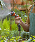 Person watering plants with three quarter inch garden hose quick connector kit. Three quarter inch garden hose quick connector kit six pack with aluminum male and female quick connectors includes rubber washers easy connect and quick release rubberized grips for hassle free water fittings.