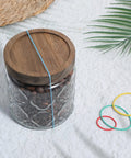 Glass jar with wooden lid secured by rubber band, surrounded by colored rubber bands; suited for 60 Pcs Rubber Pulley Belt Set For RC Cars Airplanes Robots Trucks And DIY Models Durable Transmission Belts In Multiple Sizes 23mm To 60mm Includes Colored Rubber Bands Must Have Replacement Parts And Toy Accessories.