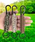 Hand holding three Six Pack Paracord Keychains With Carabiner Clip And Braided Lanyard For Keys Backpacks And Outdoor Gear
