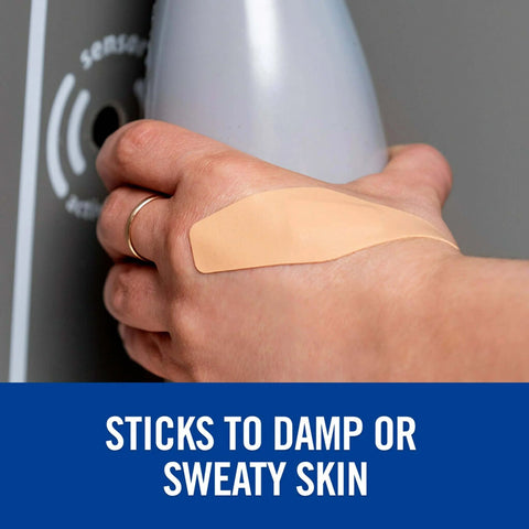 Person wearing a Waterproof Cushioned Foam Bandage on hand, demonstrating adhesive on damp skin, for cuts scraps blisters, with minimal residue