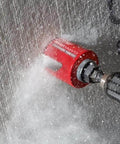 Milwaukee 4-1/4 in Big Hawg carbide hole saw attached to a drill drilling into concrete.