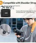 Camera Quick Release Plate And Tripod Mount Adapter For Gimbals Sliders And DSLRs With One Quarter Inch And Three Eighth Inch Screws Arca Swiss Compatible Up To Twenty Kilograms Built For Pro Grade Stability shown with a shoulder strap for easy carrying.