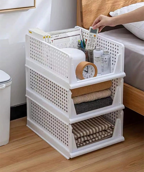 Four Pack Foldable Wardrobe Storage Boxes, Stackable Clothes Drawer Organizers next to bed with various items stored