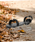 Pair of Pro Grade Lawn Aerator Shoes with 20 heavy-duty metal spikes on a leaf-covered path. Easy to wear lawn care tools.