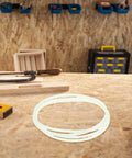 Tough As Nails Rubber Drive Belts Pack Of Four For Heavy Duty Industrial Sealers on workbench amidst tools.
