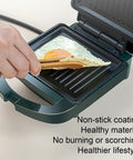 Hand using wooden tongs on Compact Electric Sandwich Maker And Grill Press For Perfect Grilled Cheese with egg.