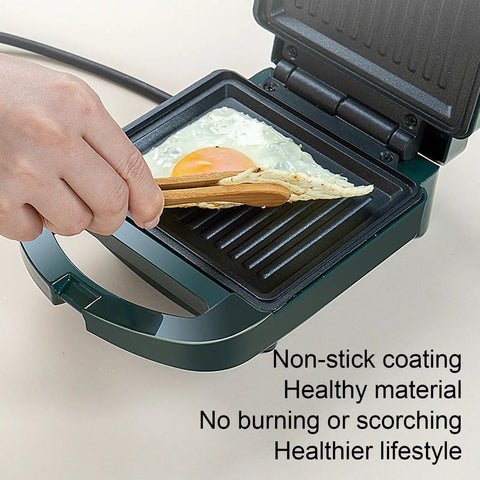 Hand using wooden tongs on Compact Electric Sandwich Maker And Grill Press For Perfect Grilled Cheese with egg.