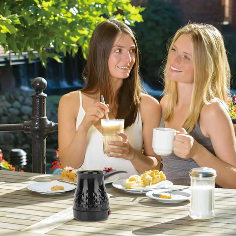 Two women enjoying coffee outdoors with Portable Turkish Coffee Pot 600ml Electric Kettle on table.