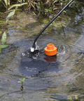Submersible Water Pump One Third HP 2500GPH Portable Electric Utility Pump in use for water drainage in pond.