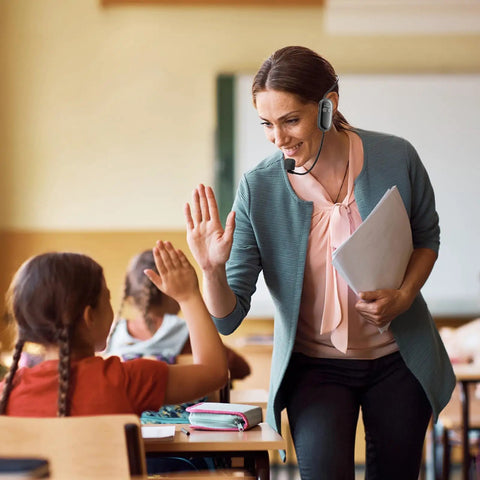 Teacher using Wireless Mic Headset 2.4G System with USB C Charging and 100 Ft Range in classroom interacting with student