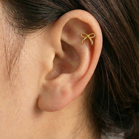 Gold Bow Stud Earrings For Women Titanium Flat Back Screw Back Hypoallergenic Nickel Free Lightweight showcased on an ear.