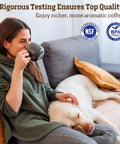 Woman enjoying coffee while sitting on a couch with a dog, representing quality coffee experience and comfort.