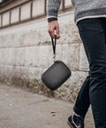 Person walking with Rugged 2.5 Inch External Hard Drive Case Organizer Box Fits Seagate WD Elements Toshiba Canvio UnionSine Portable HDDs 1TB To 4TB SD Card And USB Drive Holder Box Only in hand.