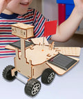 Child playing with Solar Powered Mars Rover Kit Made Of Wood For DIY Engineers A Dope Educational STEM Project on table