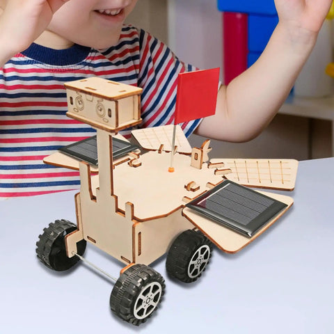 Child playing with Solar Powered Mars Rover Kit Made Of Wood For DIY Engineers A Dope Educational STEM Project on table