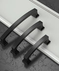 Three oil rubbed bronze cabinet handles on black marble, each with 4 inch hole centers, part of the 30 pack kitchen cabinet pulls set.